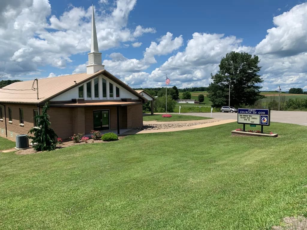 The Dayton First Church of God building, brick with a white steeple, viewed from the lawn off State Route 839.